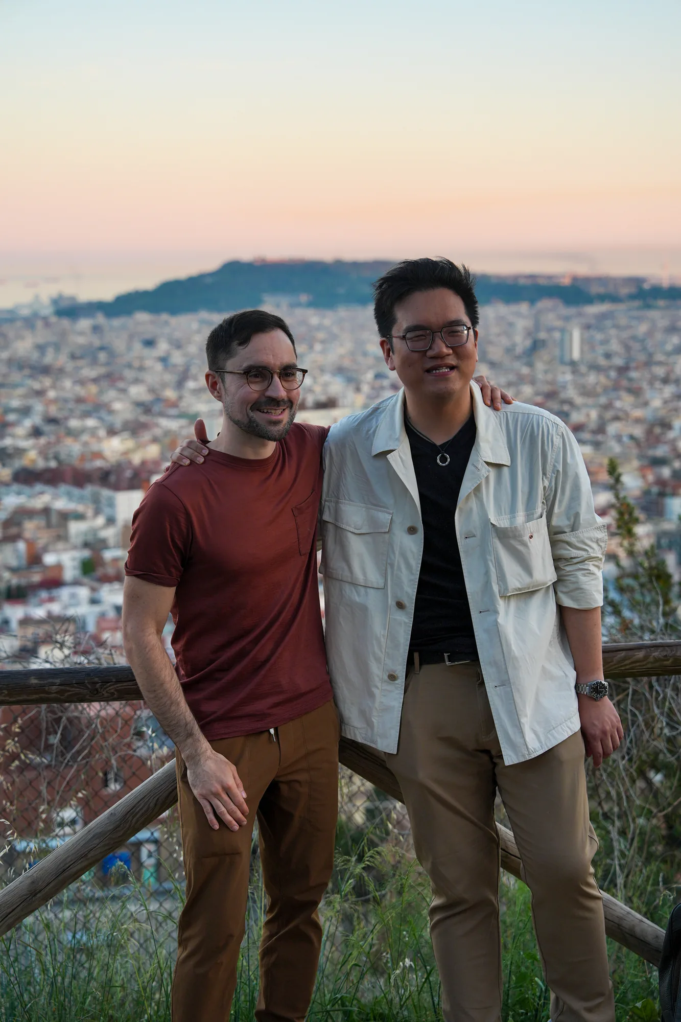 Two Blau students above Barcelona at sunset, with the sea behind