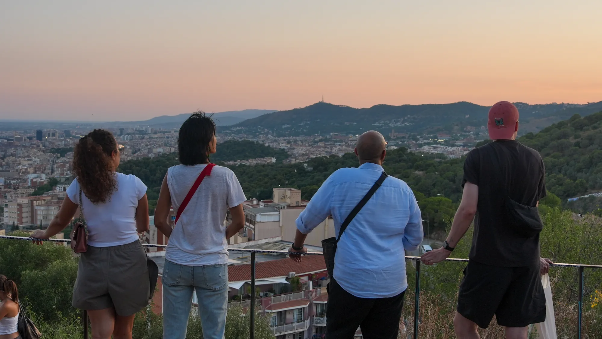 Four students looking out over Barcelona at sunset from the Bunkers del Carmel