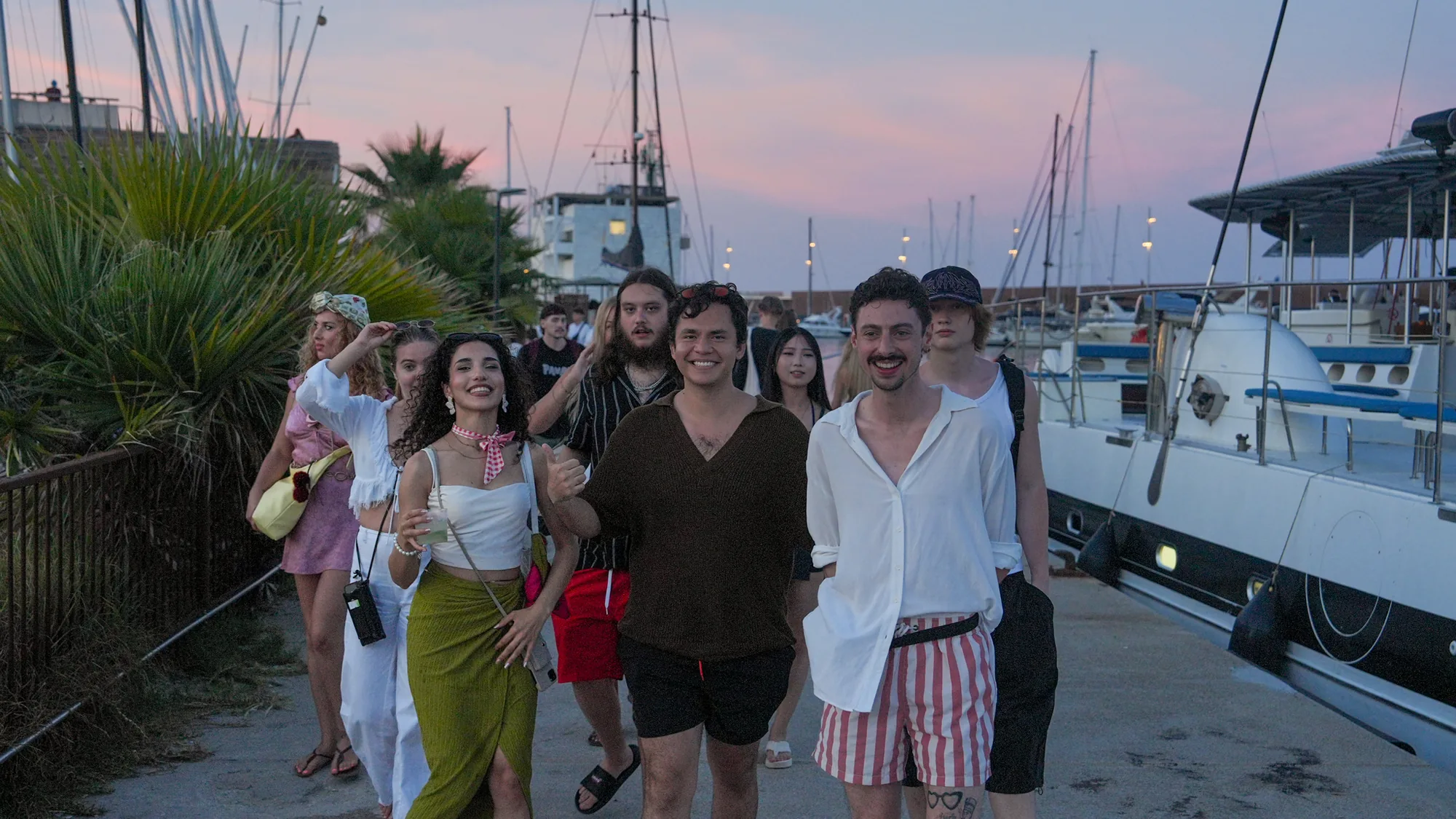 Students walking along the port at dusk after a sunset catamaran trip