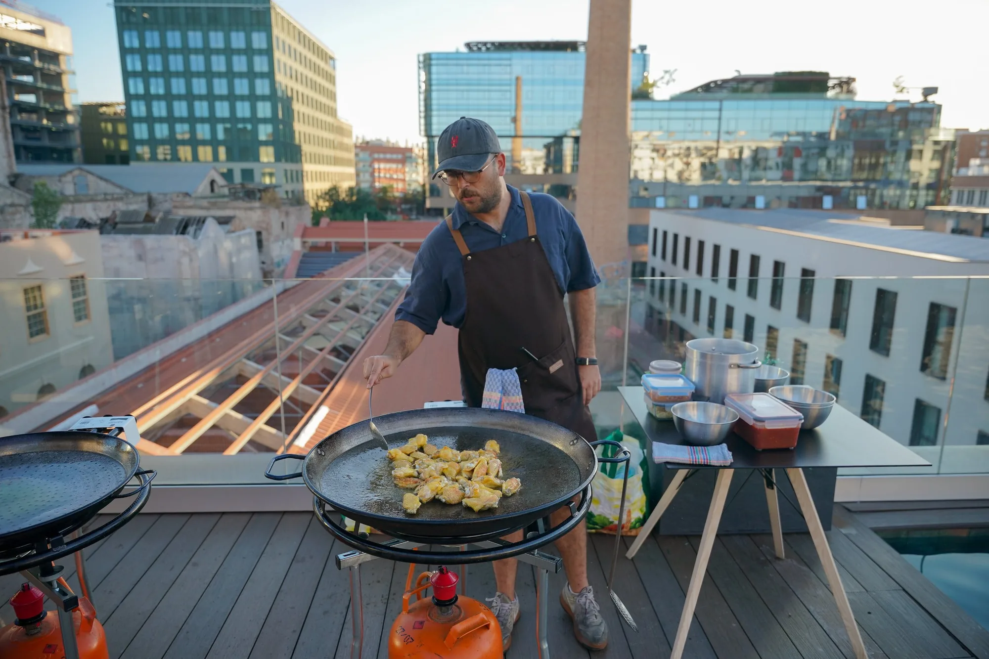 Paella being cooked on the rooftop at sunset
