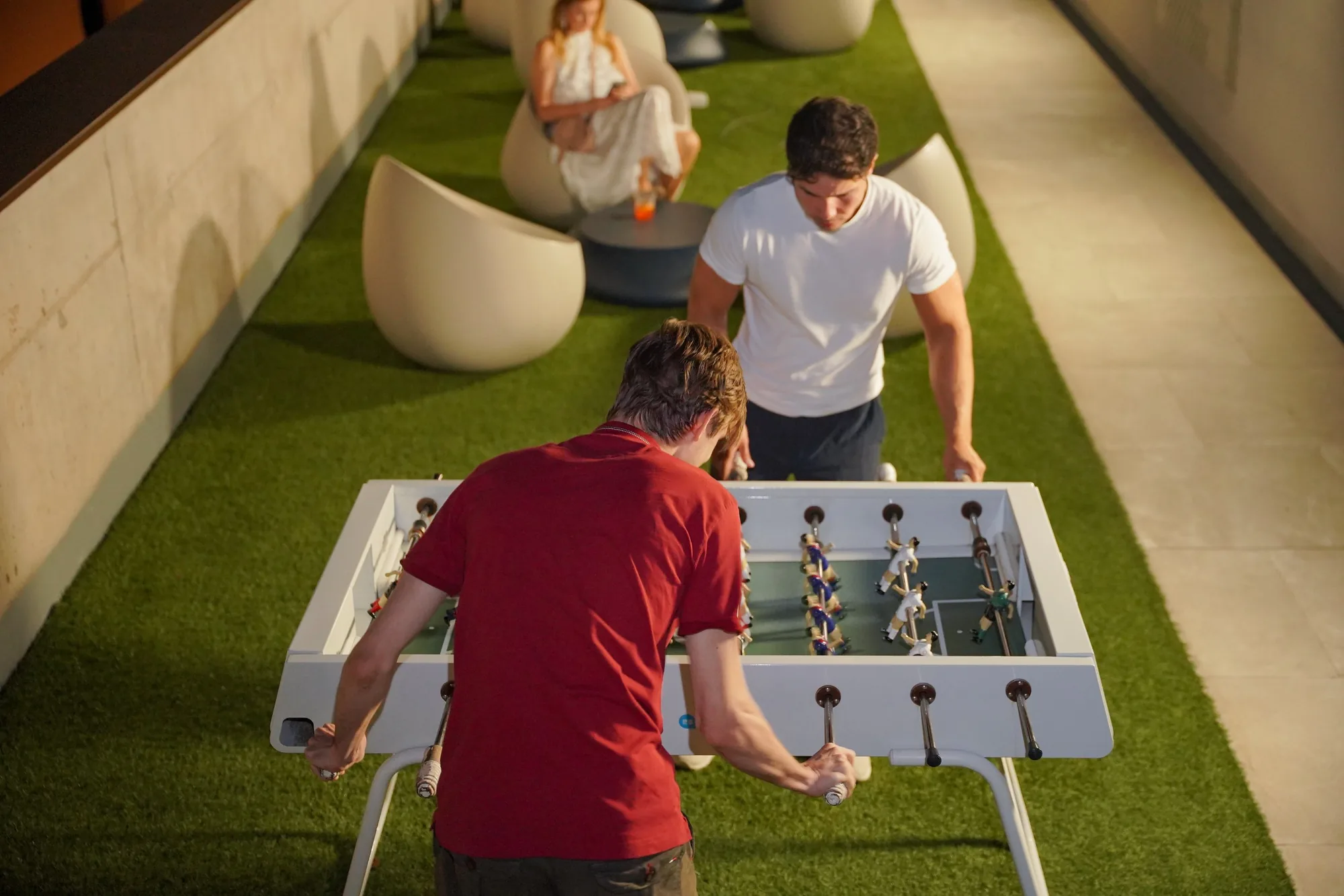Two students playing foosball on the terrace